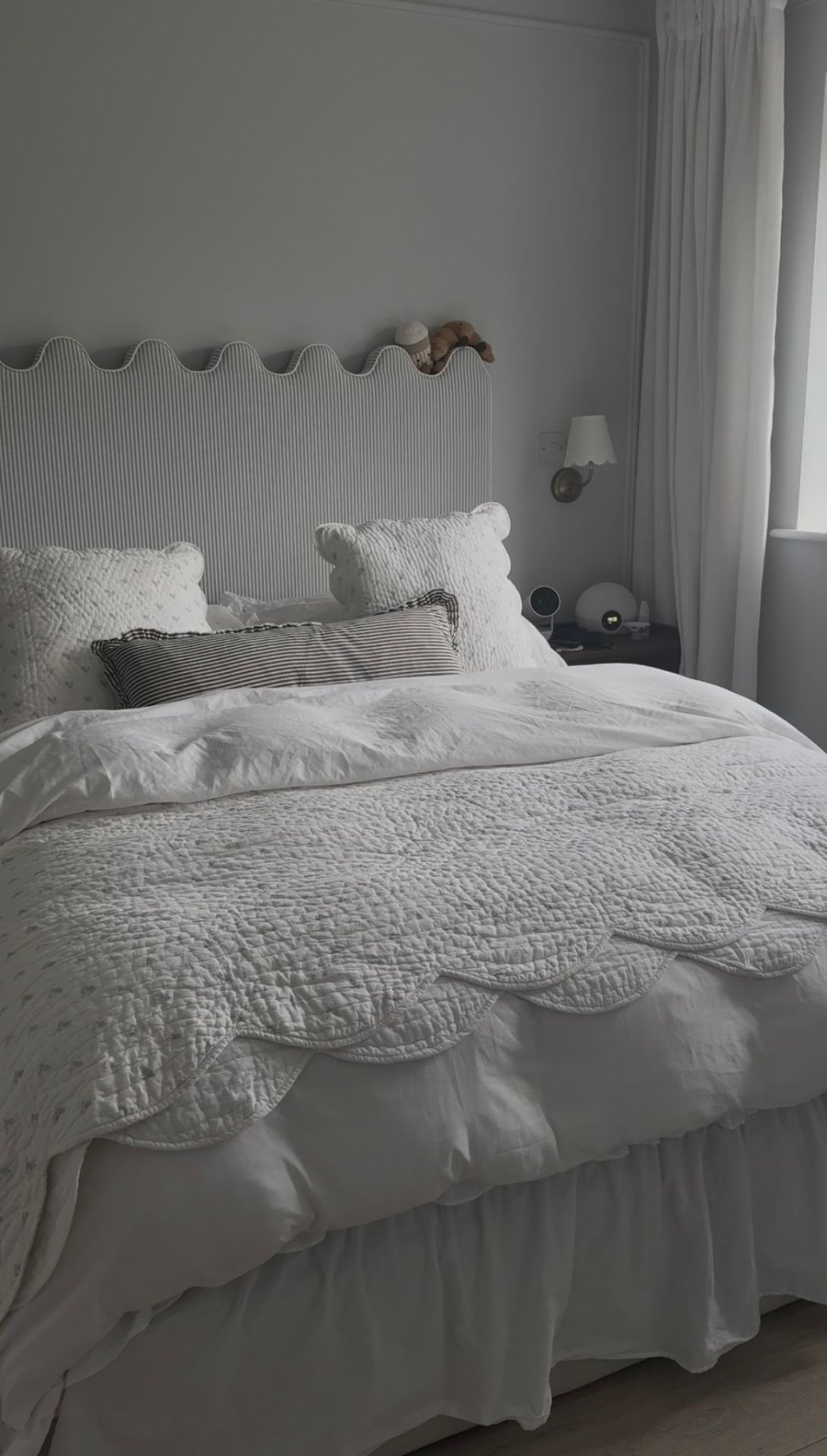 Bespoke scalloped upholstered headboard in a residential bedroom