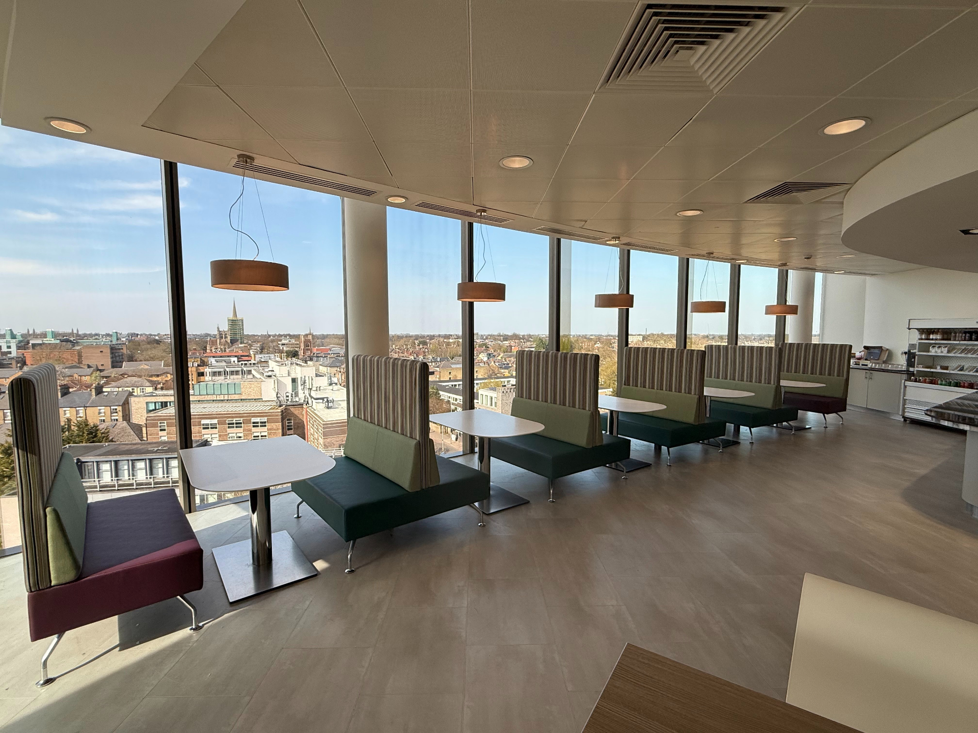 Bespoke office breakout booth seating installed against a floor-to-ceiling window by Red Kite Furniture