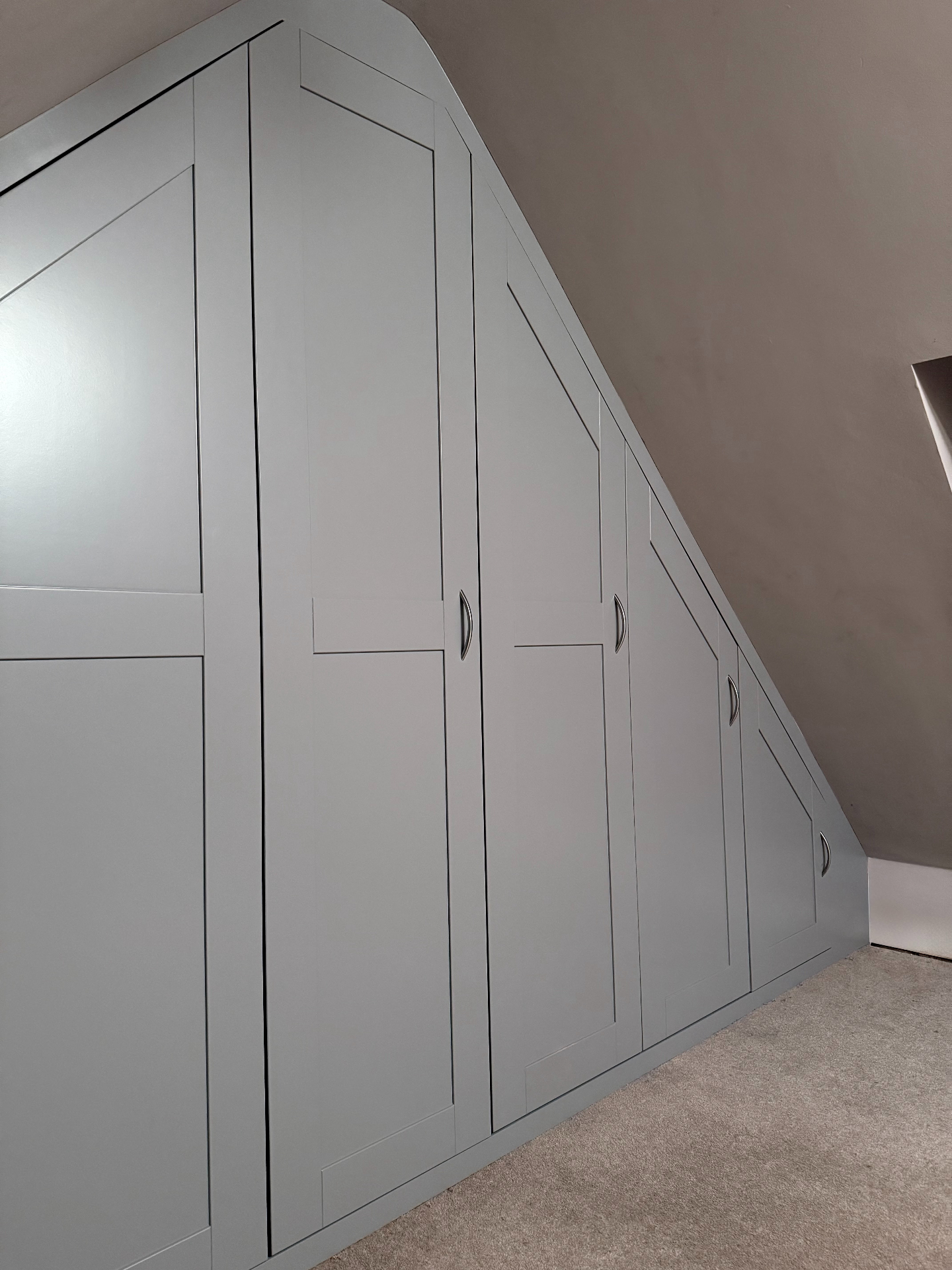 Bespoke fitted eaves wardrobe with panelled doors in a Norwich attic bedroom