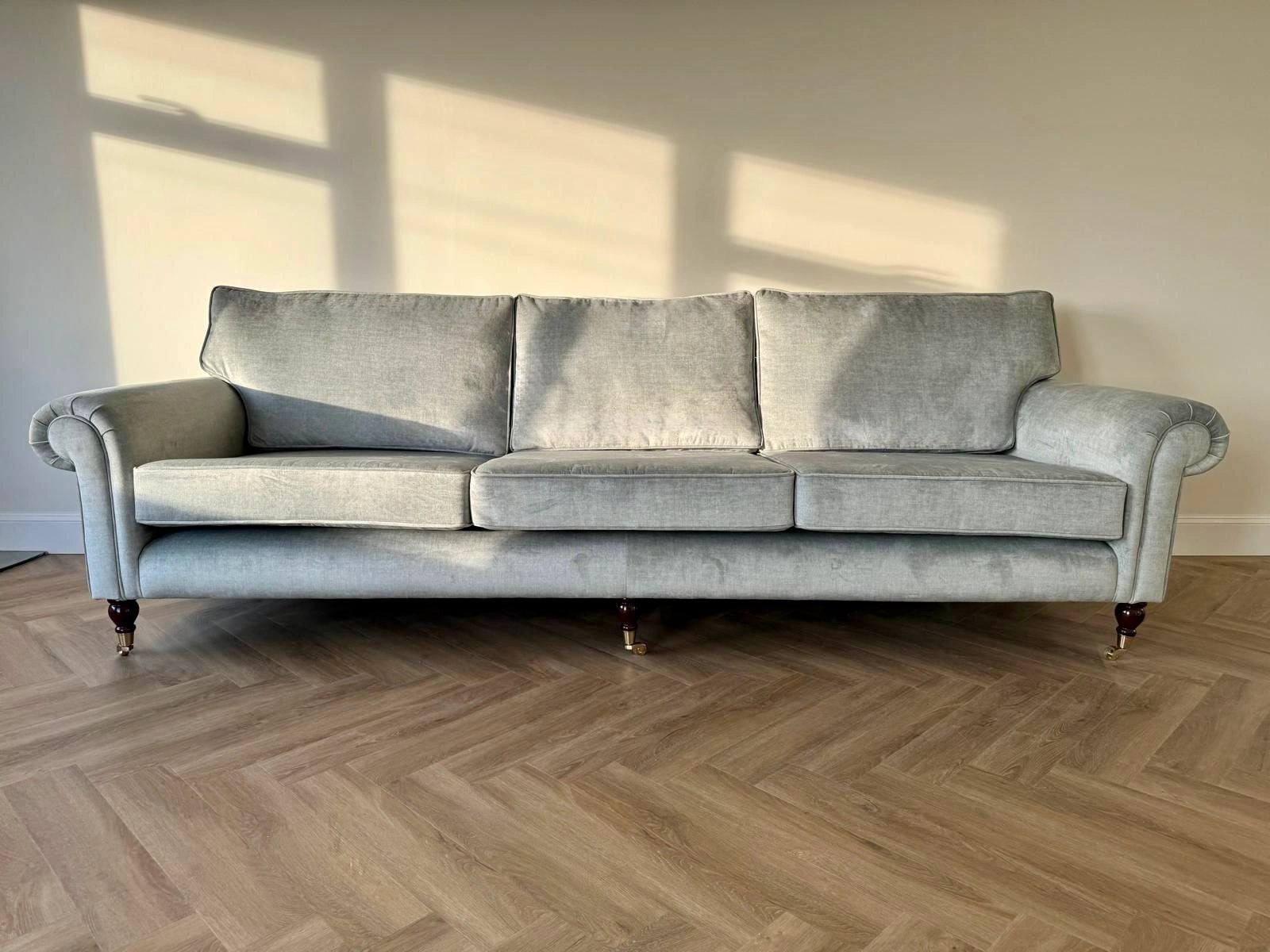 Reupholstered three-seat sofa in soft grey velvet with matching feather-wrap cushions, finished in the Red Kite Furniture workshop