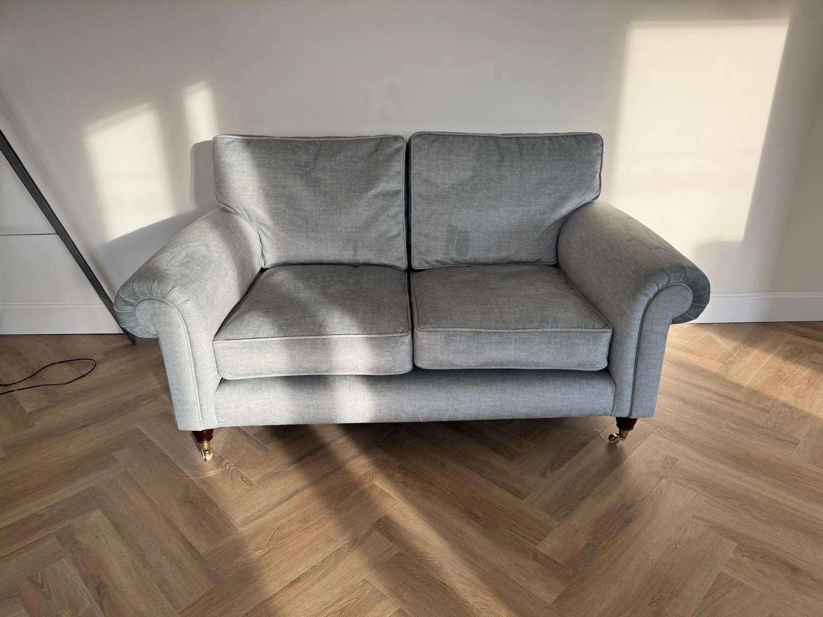 Reupholstered two-seat loveseat sofa in a mid-grey woven fabric